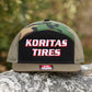 Koritas Tires 7 panel trucker hat sitting on a rock.