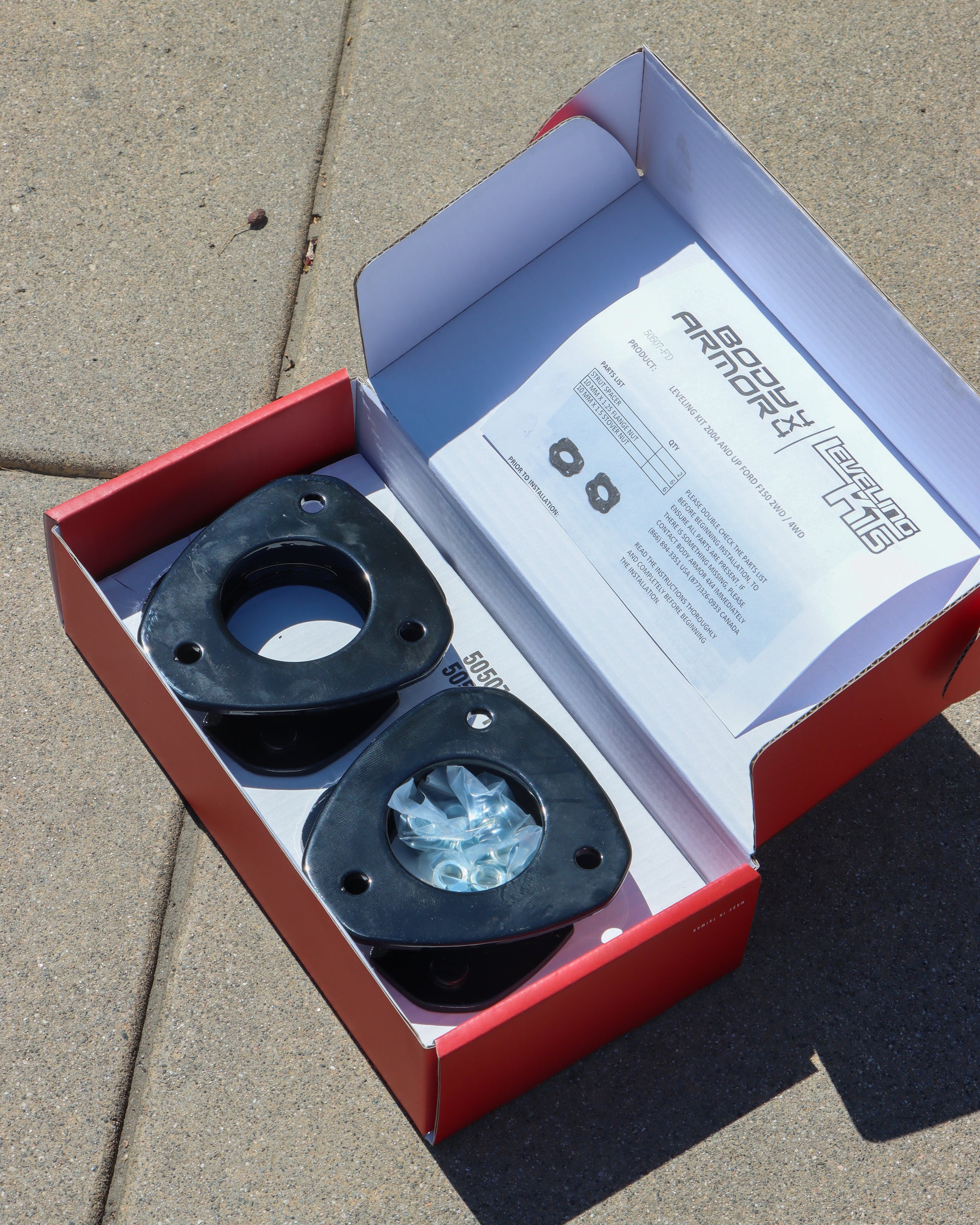 Leveling kit on display in the box with the hardware inside.