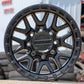 Raceline Krank Wheel in a matte black finish sitting on concrete with tires and a metal building in the backround.