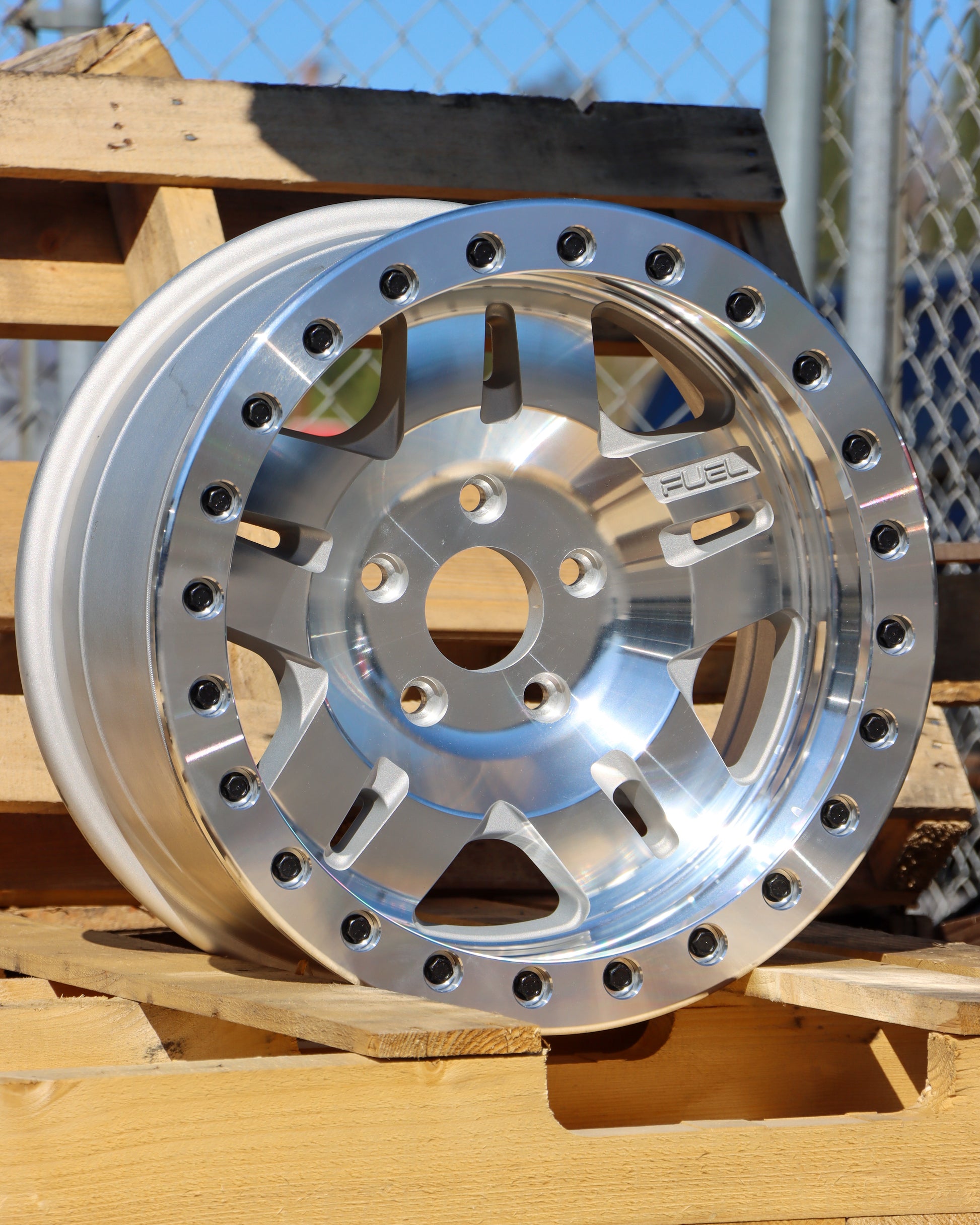 The Fuel Anza Beadlock Wheel in a machined finish, sitting on some pallets. 