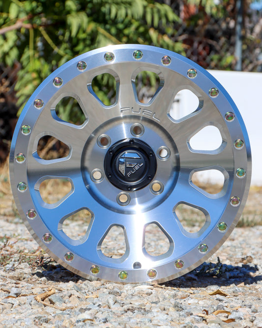 Machined finish Fuel Vector wheel lying on some gravel, with trees in the background.