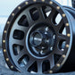 Method MR309 Grid wheel in a matte black finish sitting in a tire.
