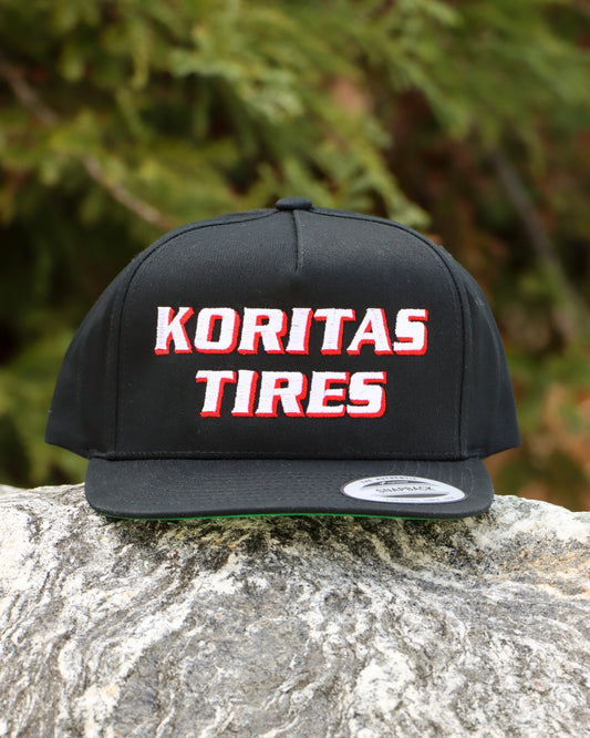 Koritas Tires Classic Snapback sitting ion a rock.
