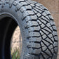close-up of the nitto ridge grappler showing the tread and sidewall with a brick wall in the background.