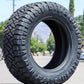 Nitto ridge grappler tire sitting in the middle of the street with the mountains and trees in the background. 