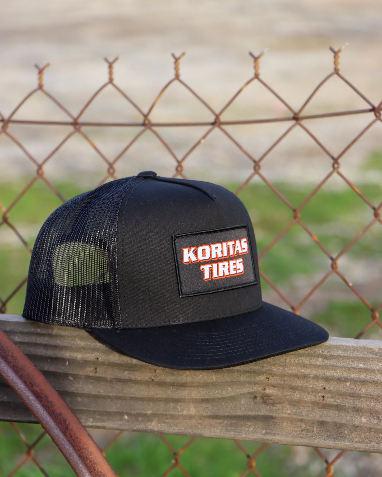 Koritas Tires Trucker Hat Sitting on a fence.