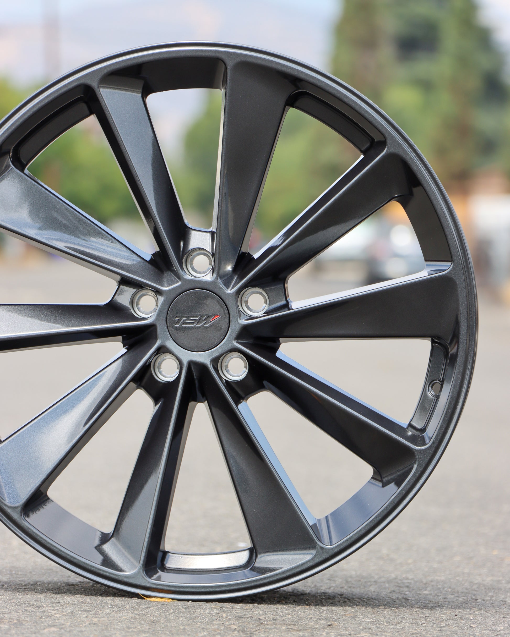 TSW Aileron Wheel in a gunmetal gray finish sitting in the middle of the street.