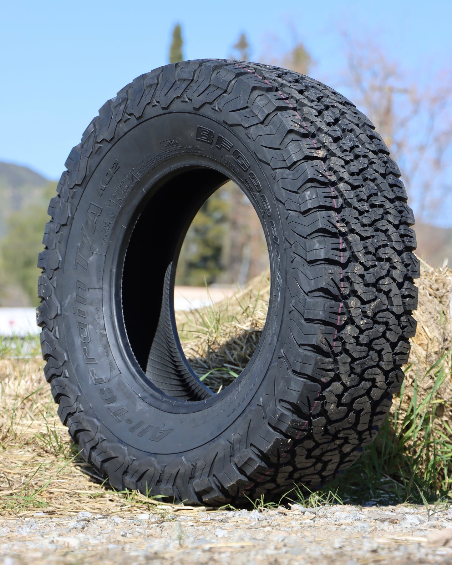 285/70r17LT BFGoodrich all-terrain KO2 tire sitting in a field.