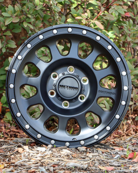 Method MR315 Wheel in a matte black finish, sitting in some woodchips.